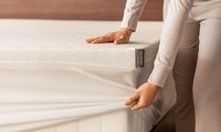 A woman putting a cloud topper on the mattress